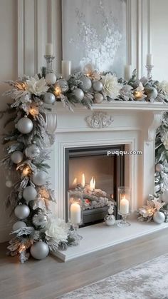 a fireplace decorated for christmas with silver and white decorations on the mantle, candles and garland