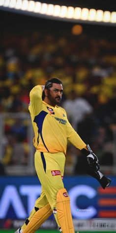 a man in yellow and blue uniform walking across a field