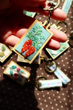 a person holding onto a keychain with red hearts on it and other items