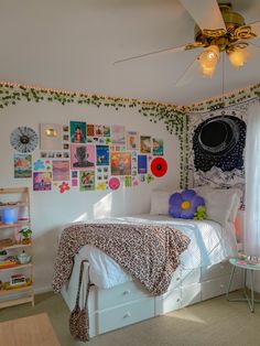 a bed room with a neatly made bed and lots of pictures on the wall