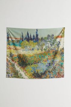 a tapestry hanging on the wall with an image of a garden and trees in it