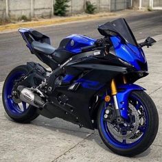 a blue and black motorcycle parked on the street