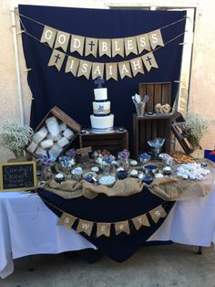 a table topped with cakes and desserts under a banner