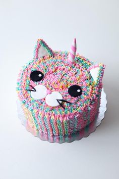 a cupcake decorated with sprinkles and a cat's face