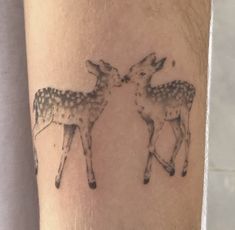 a couple of deer standing next to each other on a person's arm,