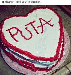 a heart shaped cake with the word pua written in red and white frosting