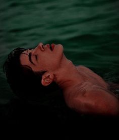 a man is floating in the water with his eyes closed