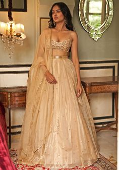 Featuring a muted golden pleated lehenga, crafted from organza tissue and adorned with delicate hand embroidery. This exquisite lehenga is perfectly paired with a stunning modern cut blouse with gold hued hand embroidery. Completing the look is an organza dupatta, delicately enhanced with beautiful detailing. This ensemble exudes charm and elegance, perfect for a cocktail party for a bride to be. Composition : Lehenga, Blouse - Organza Tissue, Dupatta - Silk Organza Care: Dry Clean Only and Vacuum Storage This product can be customized for sleeves, length of blouse and neckline Delivery : 4-6 weeks as the product is hand crafted. Check Size Guide or choose MySize for free customisation (All Sizes above XL can be made at 15% additional cost) For more information and sizes please contact fab Lehenga And Blouse, Gold Organza, Gold Lehenga, Organza Embroidery, Organza Lehenga, Gaun Fashion