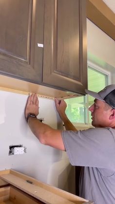 a man working on cabinets in a kitchen