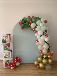 a balloon arch for a baby's first birthday with balloons and decorations on the floor