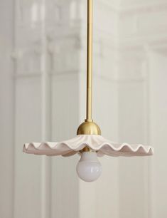 a light fixture with a white shade hanging from it