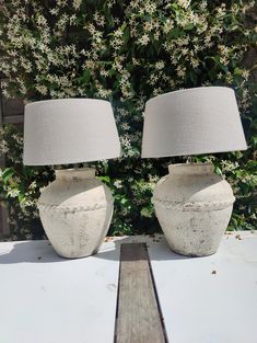 two white vases sitting next to each other on a table