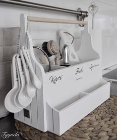 kitchen utensils and spoons are stored in a white caddy on the counter