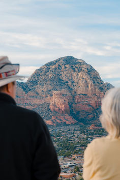 two people are looking at the mountains in sedona