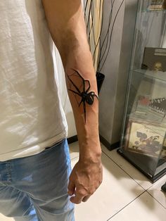 a man with a black spider tattoo on his arm