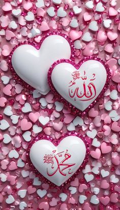 two hearts with arabic writing on them surrounded by pink and white heart shaped confetti