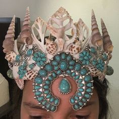 a close up of a person wearing a tiara with seashells on it