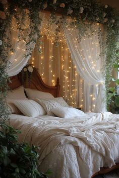 a bed with white linens and lights on the headboard is in front of a window