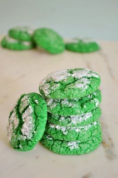 green and white cookies stacked on top of each other with powdered sugar in the middle