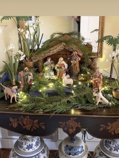 christmas scene with nativity scene displayed on mantle in living room area, surrounded by blue and white vases