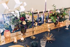 the table is set with candles, flowers and other items for an elegant wedding reception