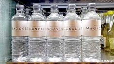 several bottles of water are lined up on a shelf