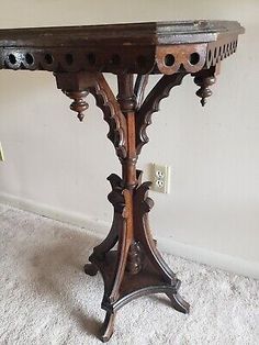 an old wooden table with ornate carvings on the top and bottom, in good condition