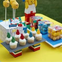 some cupcakes are sitting on a table with legos and other items in the background