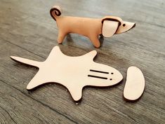 a wooden toy dog standing on top of a table next to an object that looks like a fish