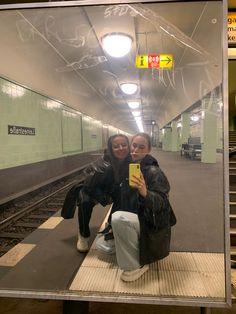 two women taking a selfie in a subway station