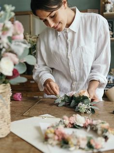 a woman in white shirt working on flowers