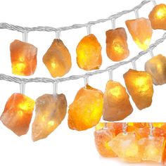 some lights that are hanging from a wire with orange crystals on them and one light is turned on