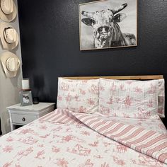 a bed with pink and white bedspread next to a painting on the wall