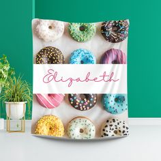 a sign that says, doughnuts with sprinkles are on display in front of a green wall