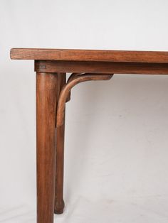 an old wooden table with two legs and a small piece of wood underneath it on a white background