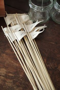 several wooden sticks sitting on top of a table next to some jars and spoons