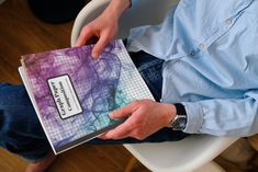 a person sitting on a chair holding a book