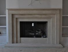 an empty living room with a fireplace and bookcases