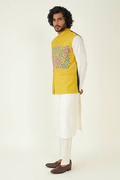 Bold mustard hue bundi with multi colored floral embroidery on the front and color block back. - Aza Fashions Fitted Multicolor Nehru Jacket For Festivals, Cotton Nehru Jacket With Floral Embroidery, Traditional Cotton Nehru Jacket With Floral Embroidery, Cotton Bandhgala With Zari Work For Puja, Transitional Embroidered Multicolor Bandhgala, Transitional Multicolor Nehru Jacket, Traditional Cotton Nehru Jacket With Chikankari Embroidery, Traditional Yellow Nehru Jacket For Festivals, Festive Multicolor Nehru Jacket With Floral Embroidery