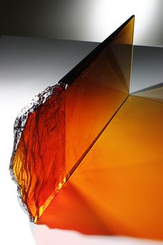 an orange piece of glass sitting on top of a table