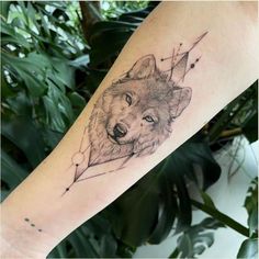 a tattoo with a wolf on it's arm and an arrow in the middle