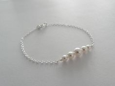 White pearl bracelet- ALL PARTS ARE SOLID STERLING SILVER *White swarovski pearls are 6mm, 5mm, and 4mm *Sturdy chain clasps closed with a larger and thicker spring style clasp *Boxed individually & ready to give Notes: This bracelet is very sturdy without being big or bulky. All components are high quality and solid sterling. Makes a great gift for bridesmaids as it will last a lifetime. Classic Silver Pearl Bracelet For Bridesmaids, Minimalist Sterling Silver Pearl Bracelet For Wedding, Silver Pearl Chain Bracelet For Anniversary, Dainty White Sterling Silver Bracelet For Wedding, Silver Dainty Pearl Bracelet For Bridesmaid, Delicate Sterling Silver Pearl Bracelet For Wedding, Dainty Silver Pearl Bracelet For Bridesmaid Gift, Minimalist Sterling Silver Bracelet For Wedding, Wedding Sterling Silver Round Pearl Bracelet