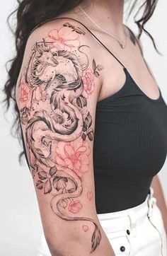 a woman with a dragon tattoo on her arm and shoulder is posing for the camera