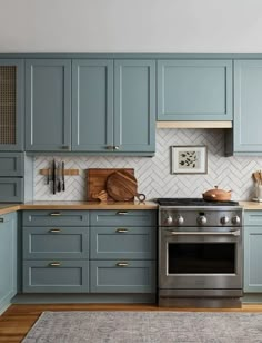 a kitchen with blue cabinets and silver appliances