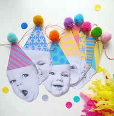 birthday hats and party decorations are laid out on a table with pom poms