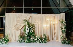 an image of a wedding stage setting with flowers and greenery on the front wall