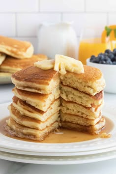 stack of pancakes with bananas and syrup on white plate