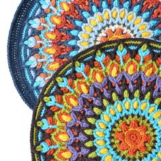 three crocheted placemats with colorful designs on them