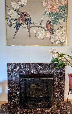 there is a painting on the wall above a fireplace with two birds sitting on it