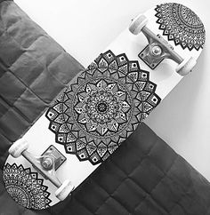 a black and white photo of a skateboard with intricate designs on the bottom part